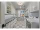 Well-equipped laundry room featuring ample storage, modern appliances, and stylish checkered flooring at 2106 E La Vieve Ln, Tempe, AZ 85284