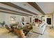 Open living room with beamed ceilings, built-in display shelving, comfortable seating, and stylish decor for relaxed living at 2106 E La Vieve Ln, Tempe, AZ 85284