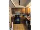 Traditional kitchen with wood cabinets, black appliances, and tile floor at 2141 W Elm St, Phoenix, AZ 85015