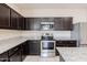 Stylish kitchen features dark cabinetry, stainless steel appliances, and granite countertops at 2220 N St Bonita Ln, Casa Grande, AZ 85122