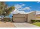 Tan single-story home featuring a two-car garage and mature landscaping at 2309 W Shawnee Dr, Chandler, AZ 85224