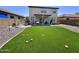 Backyard with lush artificial grass, a patio, and a two-story house at 2348 W Alta Vista Rd, Phoenix, AZ 85041