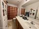 Bathroom with a double vanity, large mirror, and a shower-tub combo at 2348 W Alta Vista Rd, Phoenix, AZ 85041