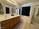 Bathroom featuring a double vanity with wood cabinets and a shower-tub combo at 2348 W Alta Vista Rd, Phoenix, AZ 85041