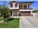 Two-story home featuring a two-car garage, red shutters, a balcony, and a well-maintained lawn at 2348 W Alta Vista Rd, Phoenix, AZ 85041