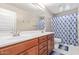 Spacious bathroom with dual sinks, and a shower featuring a stylish shower curtain at 2425 E Flintlock Dr, Gilbert, AZ 85298