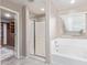 Bright bathroom featuring a shower with a bench and soaking tub under a window at 2425 E Flintlock Dr, Gilbert, AZ 85298