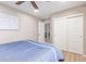 Bright bedroom with a ceiling fan and closet doors, offering ample storage space at 2425 E Flintlock Dr, Gilbert, AZ 85298