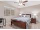 Cozy bedroom features a ceiling fan, window, and a comfortable-looking bed with side tables at 2425 E Flintlock Dr, Gilbert, AZ 85298