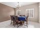 A formal dining room set with elegant table settings and decorative light fixture at 2425 E Flintlock Dr, Gilbert, AZ 85298