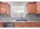 Stylish kitchen showcases granite countertops, tile backsplash, stainless steel sink, and ample natural light at 2425 E Flintlock Dr, Gilbert, AZ 85298