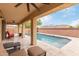 Relaxing covered patio area with comfortable seating overlooking the pool and a well-maintained backyard at 2425 E Flintlock Dr, Gilbert, AZ 85298