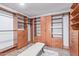 Spacious walk-in closet featuring custom shelves, drawers, hanging rods, and central seating at 2425 E Flintlock Dr, Gilbert, AZ 85298
