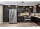 Modern kitchen with stainless steel appliances, dark wood cabinets, and a tile backsplash for a sophisticated feel at 2425 W Bronco Butte Trl # 1056, Phoenix, AZ 85085
