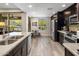 Bright kitchen featuring stainless steel appliances, stone countertops, dark cabinets, and an adjacent breakfast nook at 2425 W Bronco Butte Trl # 1056, Phoenix, AZ 85085