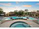 Community pool featuring a hot tub, lounge chairs, and well-maintained landscaping at 2425 W Bronco Butte Trl # 1056, Phoenix, AZ 85085