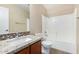 Bright bathroom featuring a granite counter and backsplash and a shower-tub combo at 2701 S Southwind Dr, Gilbert, AZ 85295