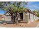 Street view of a well maintained single-story home with tan exterior and large shade tree at 2701 S Southwind Dr, Gilbert, AZ 85295