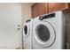Modern laundry room featuring Samsung washer and dryer, with wooden cabinets overhead at 2701 S Southwind Dr, Gilbert, AZ 85295