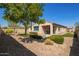 Well-maintained backyard featuring desert landscaping, trees and small seating area at 2792 N Acacia Way, Buckeye, AZ 85396
