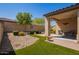 Relaxing backyard with a covered patio, artificial grass and desert landscaping at 2792 N Acacia Way, Buckeye, AZ 85396