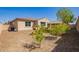 Backyard with desert landscaping, small trees, turf and the home's exterior at 2792 N Acacia Way, Buckeye, AZ 85396