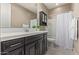 Well-lit bathroom with vanity, large mirror, and shower with white curtain at 2792 N Acacia Way, Buckeye, AZ 85396