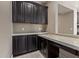 Stylish dark wood cabinets with white countertops and a small pass-through to another room at 2792 N Acacia Way, Buckeye, AZ 85396