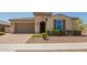 Inviting single-story home featuring a desert landscape, brick-paved driveway, and neutral-toned facade at 2792 N Acacia Way, Buckeye, AZ 85396
