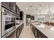 Modern kitchen with dark cabinets, stainless steel appliances, and a stylish tiled backsplash at 2792 N Acacia Way, Buckeye, AZ 85396