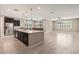 Spacious kitchen with a large island, stainless steel appliances, and modern lighting fixtures at 2792 N Acacia Way, Buckeye, AZ 85396