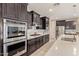 Gourmet kitchen featuring stainless steel appliances, dark cabinets, and a sleek tiled backsplash at 2792 N Acacia Way, Buckeye, AZ 85396