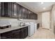Laundry room with cabinets, countertops, sink, washer, and dryer at 2792 N Acacia Way, Buckeye, AZ 85396