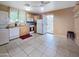 Functional kitchen with wooden cabinets, white appliances, tile flooring, and backyard access at 3108 W Butler Dr, Phoenix, AZ 85051