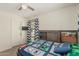Bedroom featuring carpet, a fan, a window with blinds, curtains and a mounted TV at 3528 E Tonto Dr, Gilbert, AZ 85298