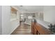 Well-lit hallway with wood floors, wooden cabinet, and a window with blinds at 3528 E Tonto Dr, Gilbert, AZ 85298