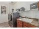 Well-equipped laundry room featuring stacked washer and dryer with sink and countertop at 3528 E Tonto Dr, Gilbert, AZ 85298