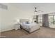 Cozy primary bedroom featuring a large window, ceiling fan, and neutral decor at 3528 E Tonto Dr, Gilbert, AZ 85298