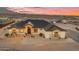 Stunning modern farmhouse with desert landscaping, beautiful sunset and a long driveway at 35280 N Bell Rd, Queen Creek, AZ 85144