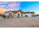 Stunning exterior with stone and wood accents, enhanced by desert landscaping, creating a welcoming entrance at 35280 N Bell Rd, Queen Creek, AZ 85144