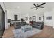 Spacious living room features modern ceiling fan, wood floors, and opens to the stylish kitchen at 35280 N Bell Rd, Queen Creek, AZ 85144