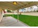 Covered patio overlooking large backyard with lush green lawn, white brick fence, and a shed at 4201 N 35Th St, Phoenix, AZ 85018
