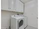 Bright laundry room featuring white cabinetry, washer and dryer with contrasting black-and-white tile flooring at 4201 N 35Th St, Phoenix, AZ 85018