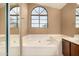 Bathroom featuring tub underneath rounded top window and shower at 4212 W Jason Dr, Glendale, AZ 85308