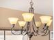 Elegant dining room chandelier with ornate metalwork and frosted glass shades, creating a warm ambiance at 4212 W Jason Dr, Glendale, AZ 85308