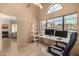 A home office features tile floors, a ceiling fan, and natural light from a large window at 4212 W Jason Dr, Glendale, AZ 85308