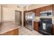 Well-lit kitchen featuring stainless steel appliances, warm-toned cabinetry, tile floors, and ample counter space at 4212 W Jason Dr, Glendale, AZ 85308