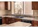 Well-lit kitchen featuring a black double basin sink, brown cabinets, and a window at 4212 W Jason Dr, Glendale, AZ 85308