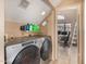 Functional laundry room with machines, storage shelves, and adjacent office space at 4212 W Jason Dr, Glendale, AZ 85308