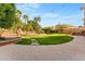 Lush backyard oasis features manicured lawn, mature trees, and ambient string lights for serene outdoor enjoyment at 4223 N St Elias --, Mesa, AZ 85215